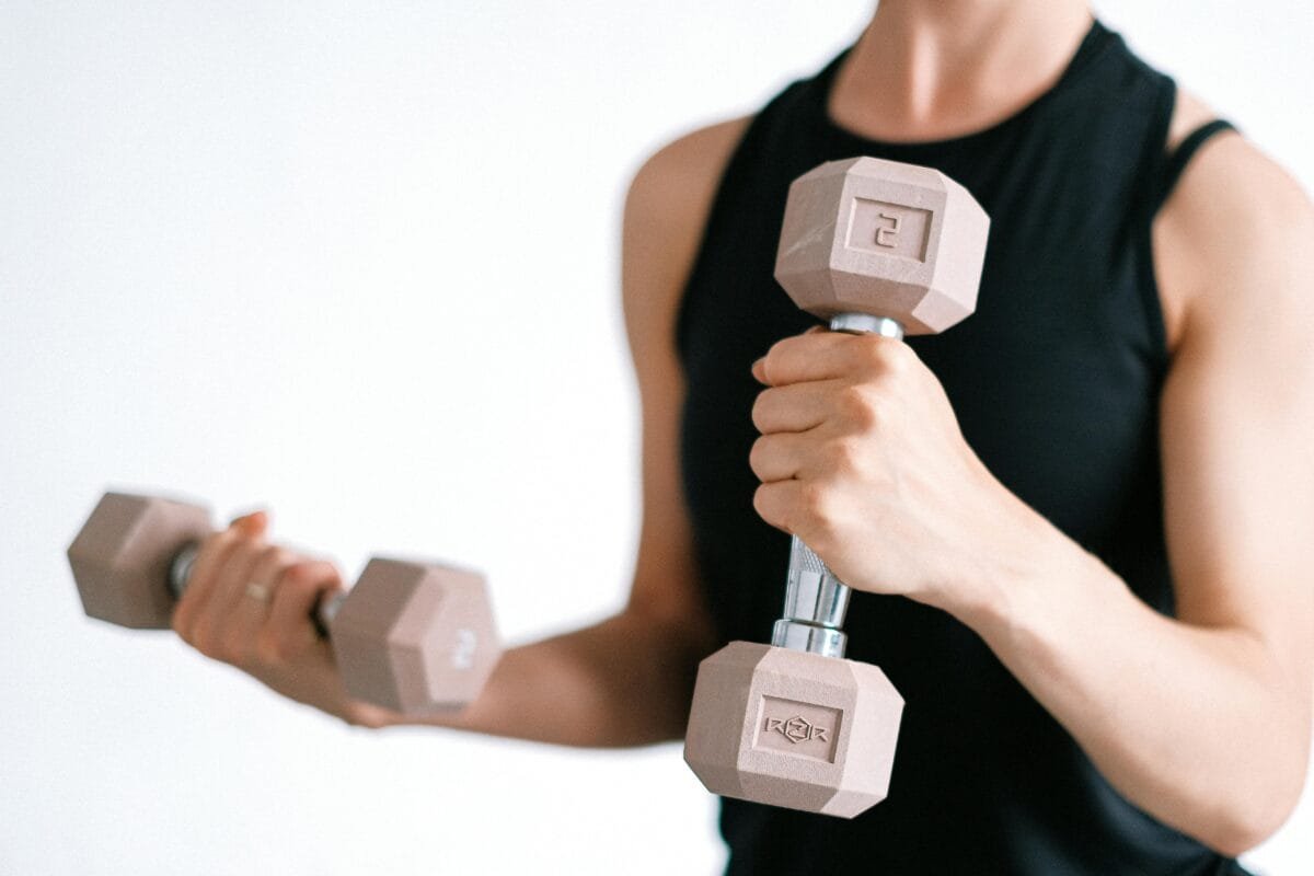 pexels-photo-4587363-4587363 Close-up of a woman lifting dumbbells, focusing on a healthy lifestyle and fitness.